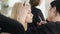 Close-up side view of blond Caucasian woman doing makeup in beauty salon. Female visagiste applying eyeliner on face of