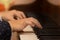 Close up side view of child hands playing the piano. Selective focus. Boy fingers and beautiful black shirt sleeves
