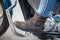 Close up, side view at female foot with protective brown boot on the stand of chopper motorbike with protective arcs