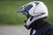 Close up side view at female motorcyclist in white helmet