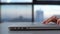 Close-up side view of hands of unrecognizable business woman opening laptop lid and starting working, sitting at desk on