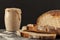 Close up side view image of a freshly baked thick crust sourdough artisan bread with an active rising sourdough starter culture in