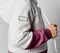Close up side view of little child hands in sports suit on gray background