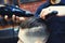 Close up side view of man getting trendy haircut by hairdresser with hair dryer at barbershop