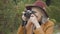 Close-up side view of positive creative senior woman taking photos on camera in spring or autumn park. Portrait of