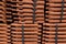 Close up and side view of stack of orange roofing tiles vibrant space for text texture