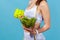 Close up side view woman in white sportswear with tape measure showing holding bowl with fresh vegetable salad and roller massager