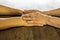 Close-up side view, wrinkled hands of an elderly Thai woman holding each other to consolation