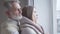 Close-up side view of young pretty Caucasian woman and senior man talking and smiling. Joyful married couple with age