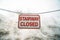 Close up of sign that reads Stairway Closed against snow covered slope in winter