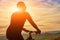 Close-up of silhouette of cyclist standing with bike against beautiful sunset.