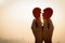 Close up and Silhouette of Woman hand holding broken paper red heart on sunset.