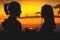 Close-up of the silhouettes of a young millenial couple in love hands are holding the sun with a man and girl against