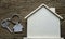 Close-up of Silver key house with house shaped keychain and home mock-up on vintage wooden table background.