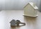Close-up of Silver keys house with house shaped keychain and home mockup on wooden table background.