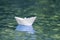 Close-up of simple small white origami paper boat floating quiet