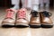 close-up of a single adult shoe between two pairs of kids shoes