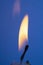 A Close Up of a Single Candle Flame and Wick on Coloured Background