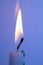 A Close Up of a Single Candle Flame and Wick on Coloured Background
