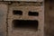 Close-up of single red brick with holes.  Brown brick wall, construction industry