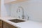 Close up of sinks in modern white kitchen with white stone
