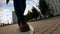 Close-up skateboarder boy riding outdoor. A young guy rides a longboard in the park. Wearing traveler boots. Urban