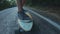 Close-up skateboarder boy riding outdoor. A young man rides a longboard on the highway. Misty road in the forest