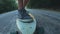 Close-up skateboarder boy riding outdoor. A young man rides a longboard on the highway. Misty road in the forest