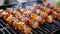 Close up of skewers with grilled meat and vegetables cooking over an open fire at a picnic gathering