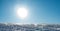 Close up of a ski resort slope with packed snow and bright sunshine