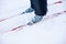 Close-up of skis and grey ski boots. Man skiing on winter snow on clear sunny day, side view