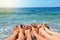 Close up of slender legs of three young girls. Blue sea in the background, the concept of a beach holiday