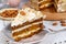 Close-up the slice  of carrot cake with almonds on a saucer and a fork near.