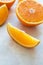 Close-up slice of orange on light table surface. Fresh citrus fruit