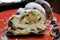 Close up of sliced christstollen with raisins, white powdered sugar and marzipan on red plate