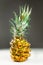 Close-up of sliced pineapple on white and grey background. Front