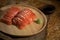 Close up of Sliced salmon placing on wooden plate together wasabi radish and shoyu on burlap