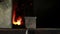 Close up slide shot of the furnace with sparkles and blacksmith takes out the