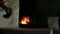 Close up slide shot of the furnace with sparkles and blacksmith takes out the