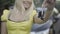 Close-up of slim female Caucasian hand holding car keys with blurred smiling blond woman looking back at new vehicle at