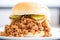 close-up of sloppy joe on a white bun, meat overflowing