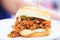 close-up of sloppy joe on a white bun, meat overflowing