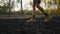 close up slow motion female hikers feet in hiking boots walks through burned grass in forest after woods fire. charred