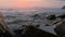 Close-up slow motion low angle small sea waves rolling on a rocky beach. Seaside. Evening sunset on a pebble rocky beach