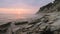 Close-up slow motion low wide angle small sea waves rolling on a rocky beach. Movement along the beach forward. Seaside