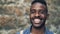 Close-up slow motion portrait of African American male with expressive face smiling showing teeth and looking at camera