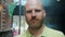 Close-up slow motion portrait of attractive bald guy with reddish beard outdoors in urban street