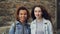 Close-up slow motion portrait of two friends beautiful girls African American and Caucasian looking at camera and