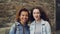 Close-up slowmotion portrait of two happy students African American and Caucasian looking at camera and laughing. Mixed