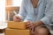 Close up Small business owner woman is writing information address product to send to customer for the online order